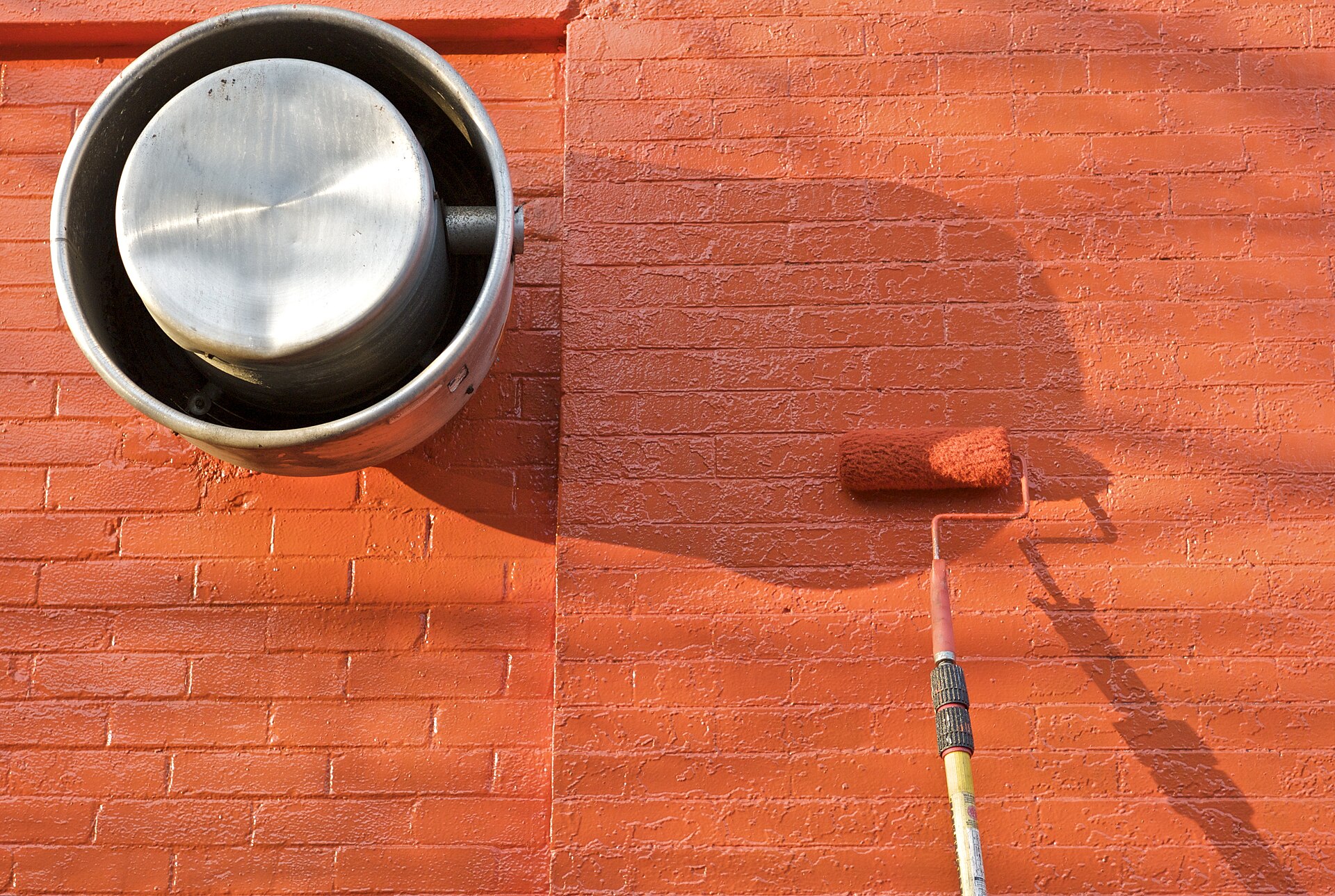 Roller applying coating on concrete
